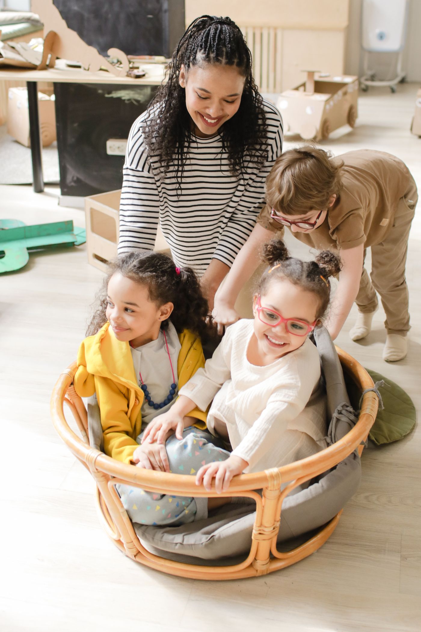 Enfants et éducatrice jouant ensemble dans la salle de la crèche
