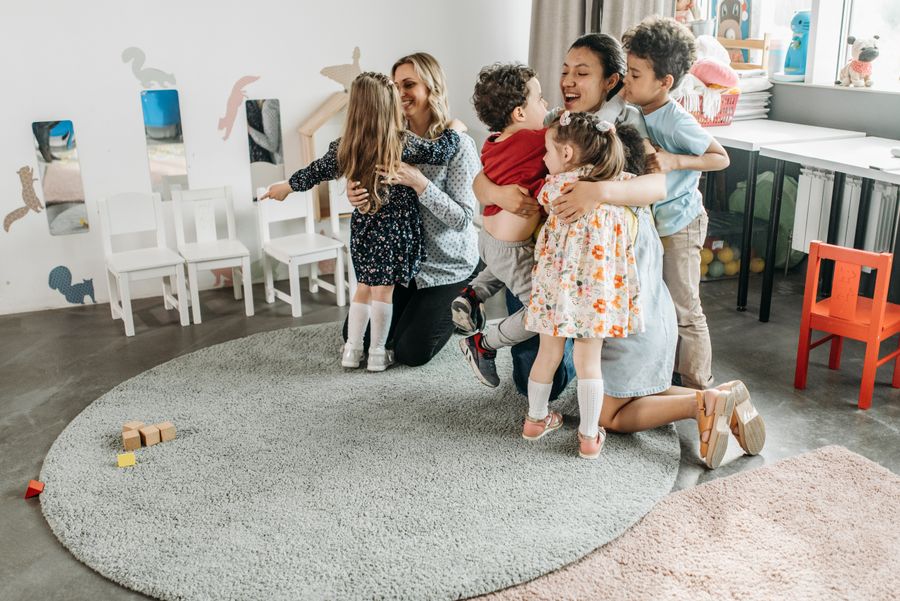Enfants et éducatrices câlinées à la crèche