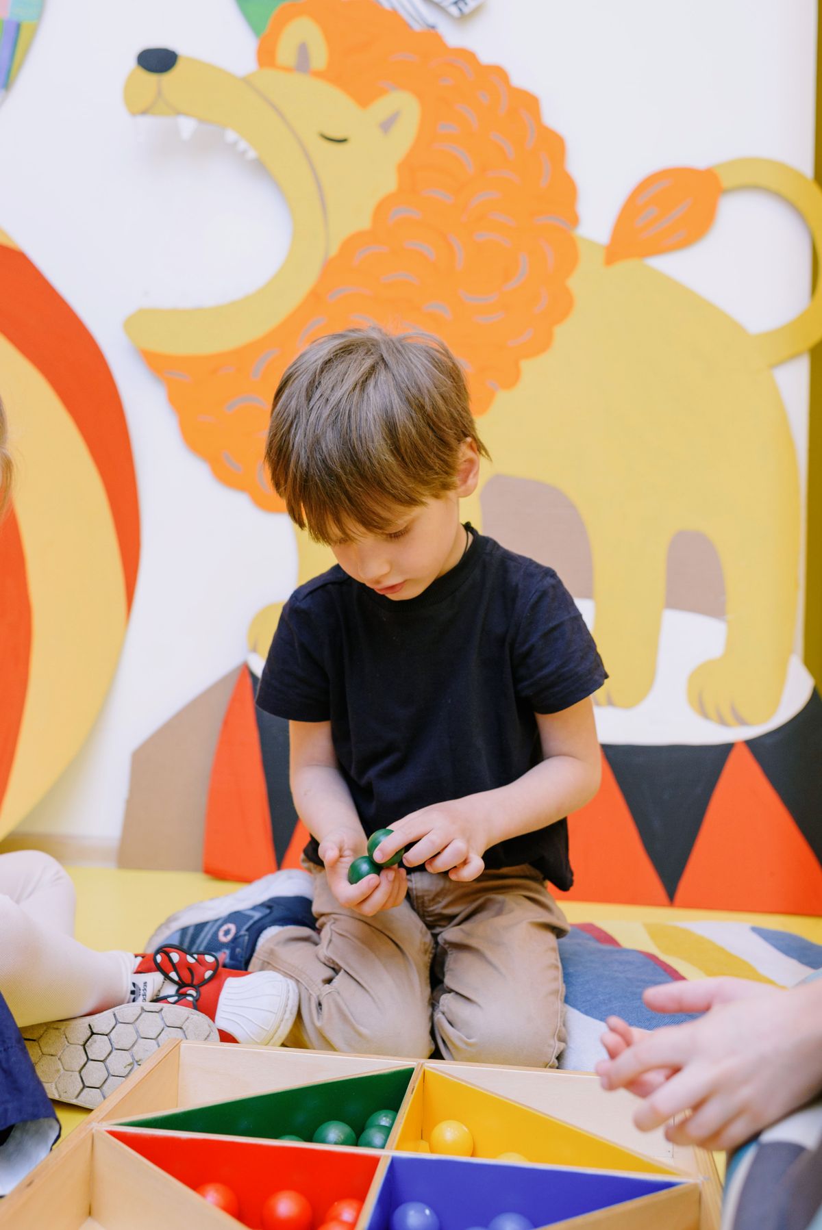 Enfant s'amusant avec des balles colorées en salle de motricité